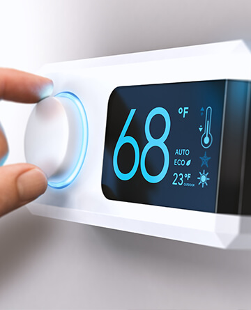 Hand turning a home thermostat knob to set temperature on energy saving mode. Fahrenheit units. Composite image between a photography and a 3D background